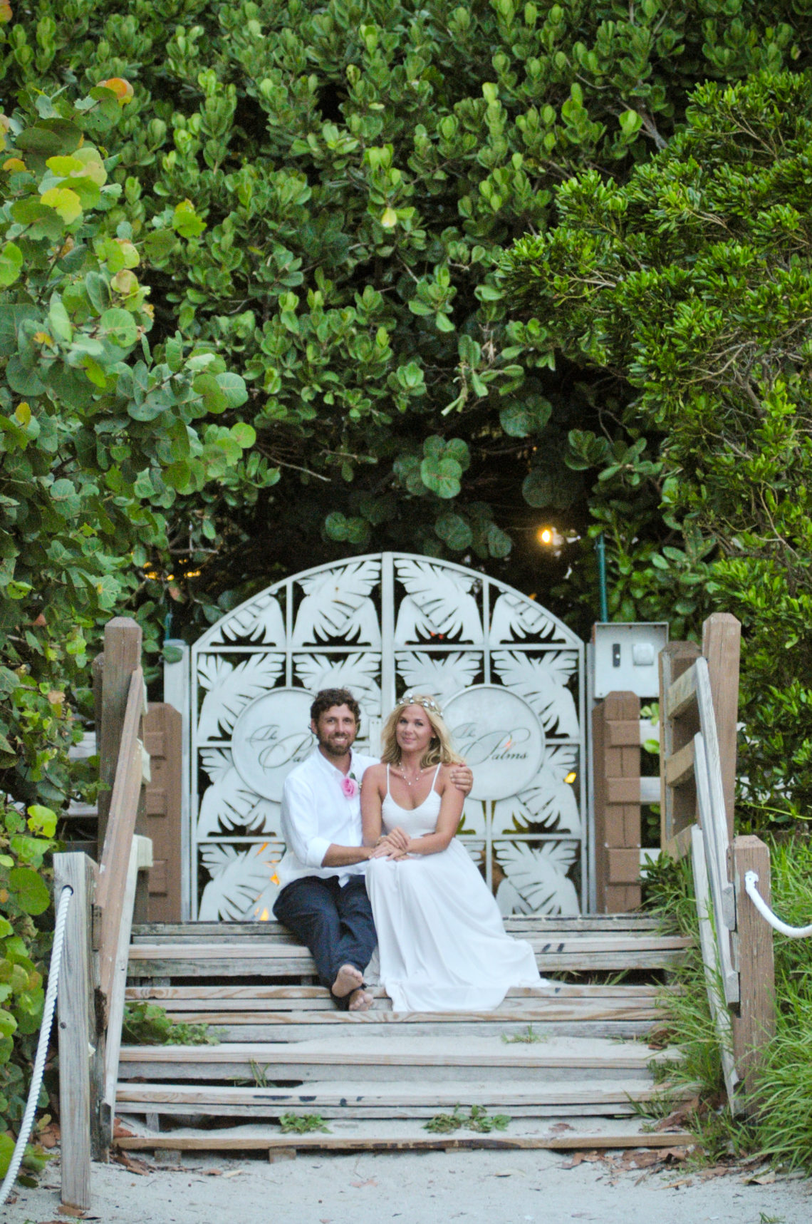 Ashley and Stephen's beautiful Miami Beach Wedding at sunset - sitting on stairs and smiling.