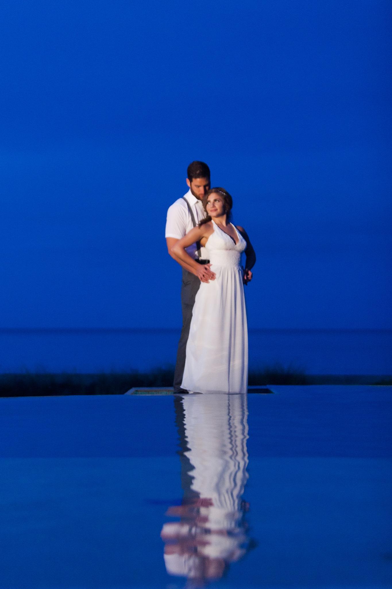 Bride and Groom embracing over infinity pool at dusk - Hutchinson Island, FL
