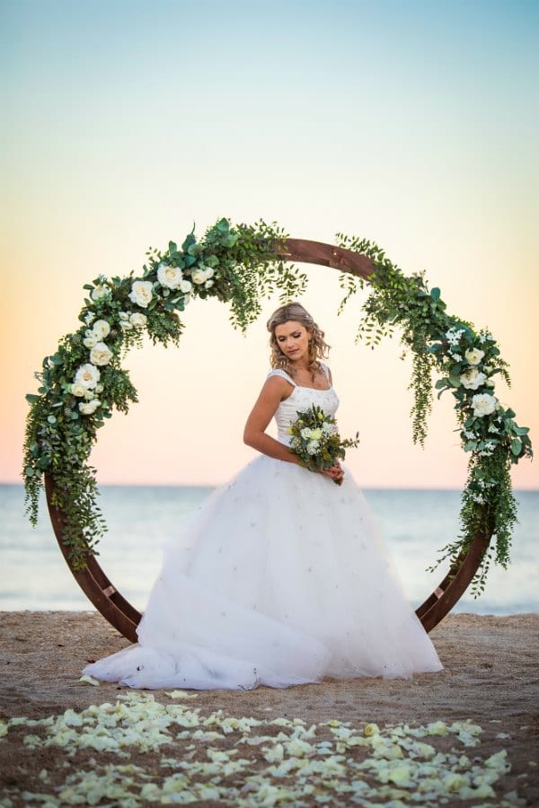 Circle Arbor at sunset with bride and white florals - beach wedding