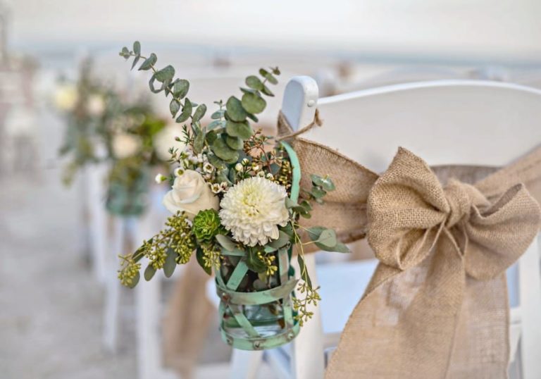 Beach Wedding Decoration of chair hanging flowers and burlap sash