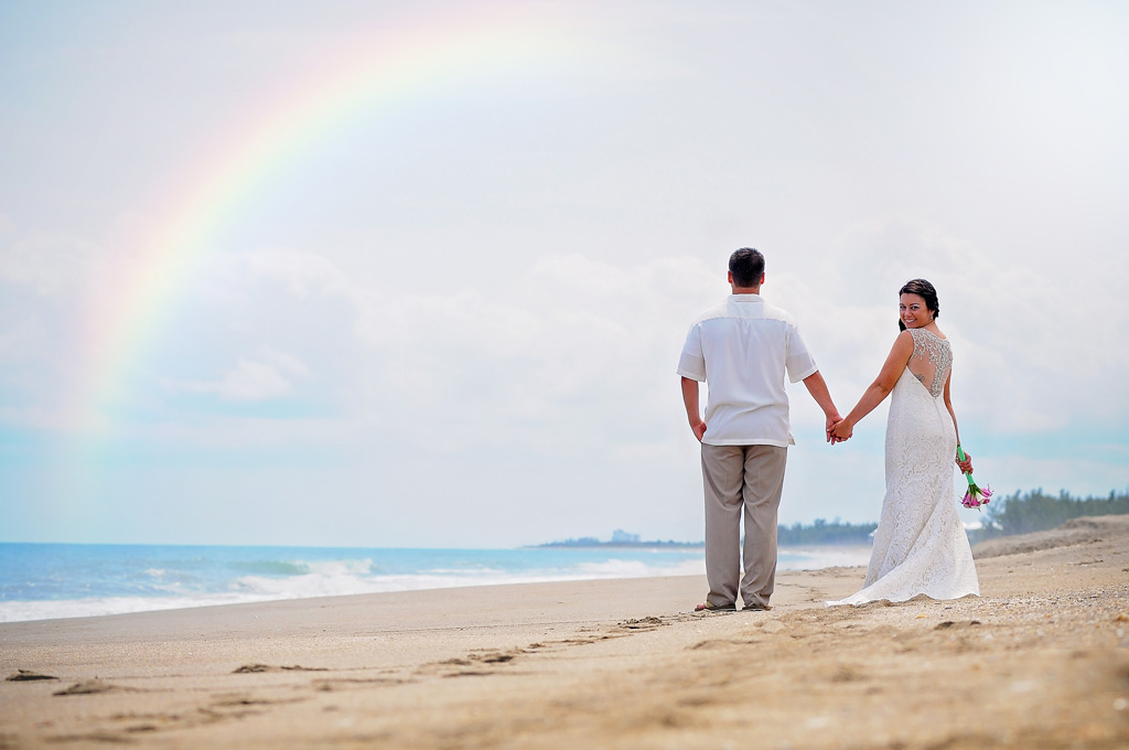 For Pierce Beach - Bride and Groom Hold Hands with a Rainbow in over the beach