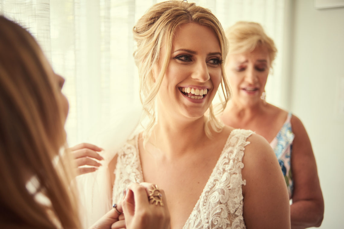 Bride smiles while getting ready at Plunge Beach Resort