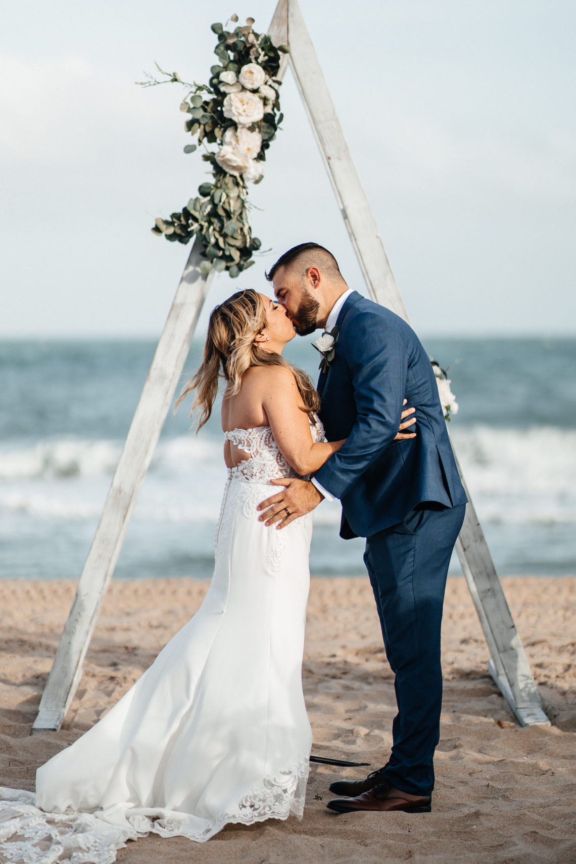 Bride and groom kiss in front of triangle arbor - Lauderdale-by-the-Sea