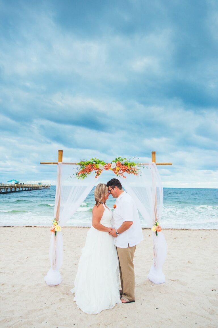 Bride and groom embrace on the beach - Lauderdale-by-the-sea