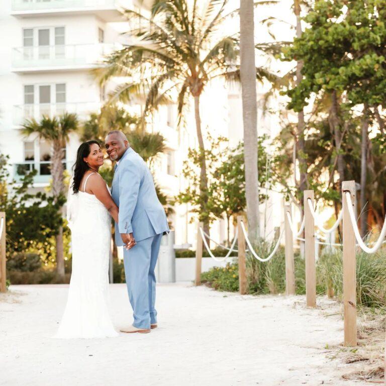 Bride and Groom stroll on miami beach with palm trees